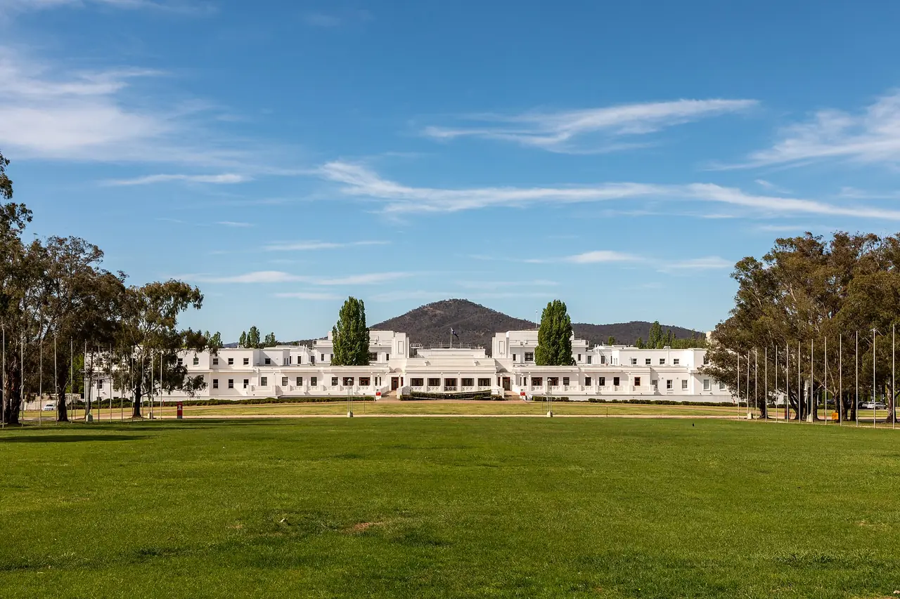 Old Parliament House ตึกสีขาวหน้าสนามหญ้ากว้าง ภาพจาก Wikimedia Commons ผู้ถ่าย Dietmar Rabich สัญญา CC BY-SA 4.0 ถ่ายปี 2019