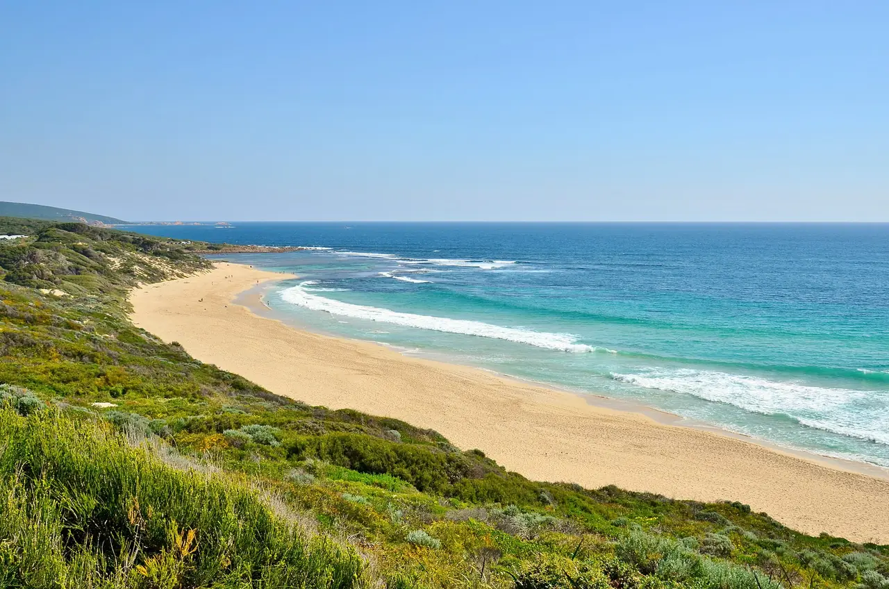 หาด Yallingup ทอดยาวเป็นแนวทรายและคลื่นสีเขียวเทอร์ควอยซ์ในภูมิภาค Margaret River ภาพจาก Wikimedia Commons ผู้ถ่าย Bahnfrend สัญญา CC BY-SA 4.0 ถ่ายปี 2015