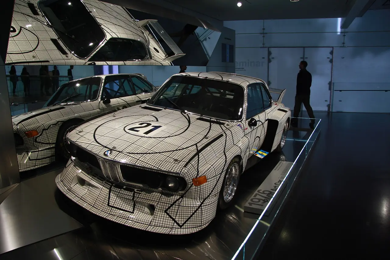 BMW 3.0 CSL Art Car ลายตารางของ Frank Stella ที่ตั้งโชว์ในพิพิธภัณฑ์ ภาพจาก Wikimedia Commons ผู้ถ่าย Jiří Sedláček สัญญา CC BY-SA 4.0 ปีที่ถ่ายไม่ระบุ รถที่ตั้งโชว์ในวันที่คุณไปอาจต่างจากภาพ