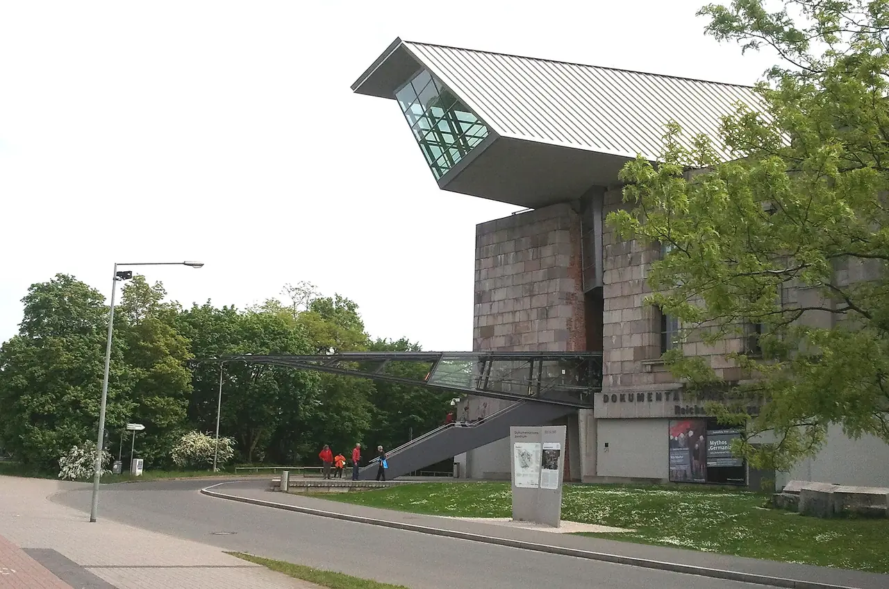 ทางเข้าศูนย์เอกสาร Dokumentationszentrum Reichsparteitagsgelände ภาพจาก Wikimedia Commons ผู้ถ่าย KaterBegemot สัญญา CC BY 3.0 ถ่ายพฤษภาคม 2554 ก่อนการปรับปรุงครั้งใหญ่ ปัจจุบันทางเข้าใหม่แล้ว