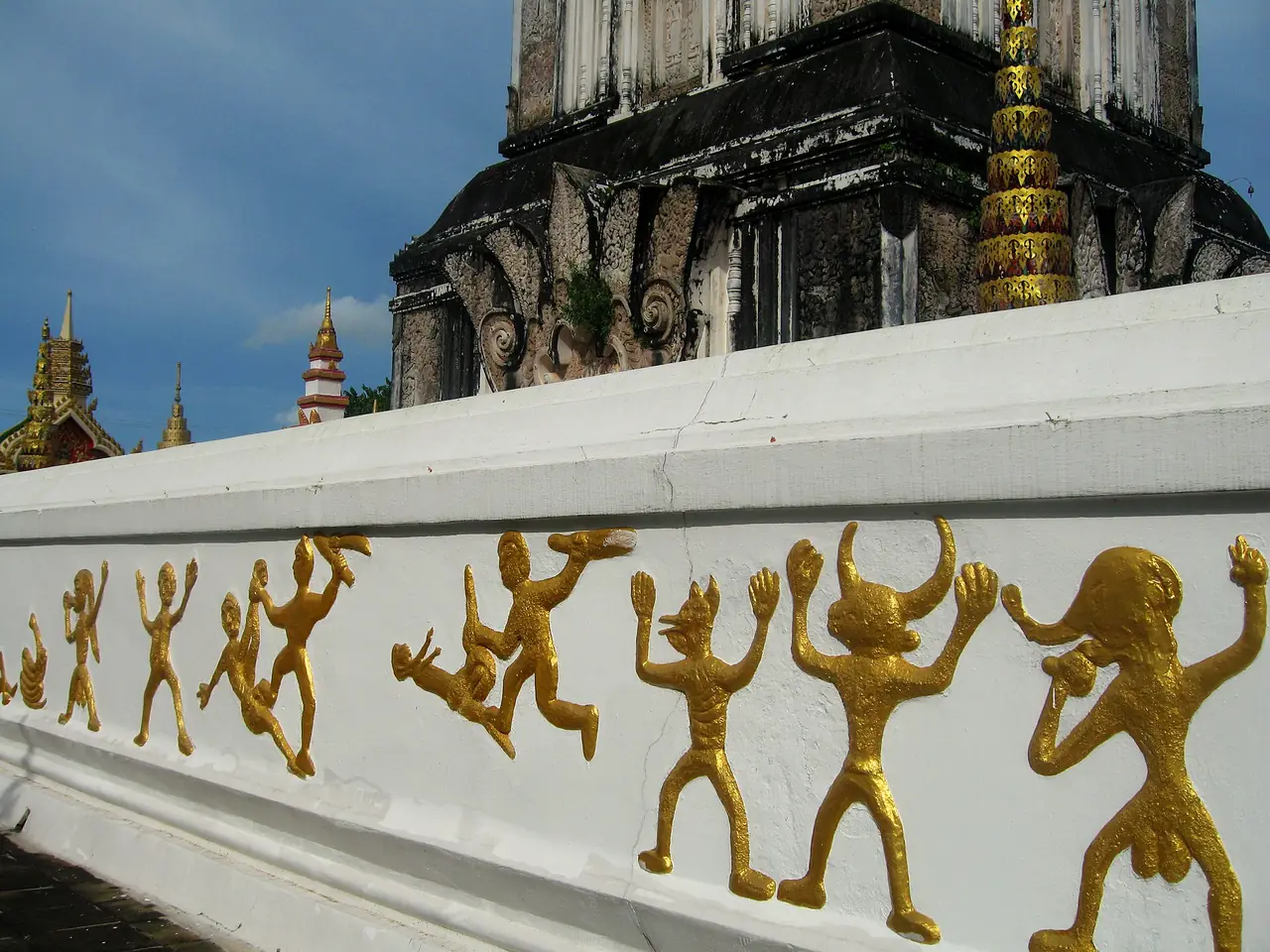 รูปปั้นปิดทองบนกำแพงรอบพระธาตุท่าอุเทน ภาพจาก Wikimedia Commons ผู้ถ่ายใช้ชื่อ ::::=UT=:::: สัญญา CC BY-SA 3.0 ไฟล์ชื่อศิลปะบนกำแพงรอบพระธาตุอยู่ในชุดเดียวกับภาพพระธาตุท่าอุเทนของผู้ถ่ายคนเดียวกัน จึงน่าจะเป็นกำแพงที่ท่าอุเทน ยังไม่ยืนยัน