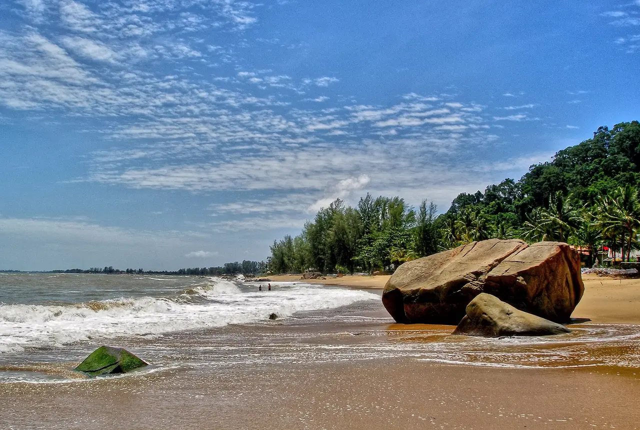 หาดทรายยาวและก้อนหินใหญ่ริมน้ำ มีต้นสนทะเลและมะพร้าวด้านหลัง ภาพจาก Wikimedia Commons ผู้ถ่าย Pedro Krtička สัญญา CC BY 3.0 ไฟล์ตั้งชื่อว่า Khao Lak Beach ไม่ระบุว่าอยู่ในหรือนอกเขตอุทยาน
