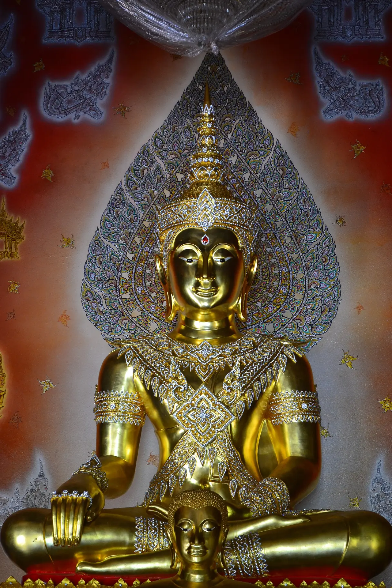 พระพุทธรูปทองประดับกระจกและลายฉลุหลังองค์พระ ภาพจาก Wikimedia Commons ผู้ถ่าย Jutawiki สัญญา CC BY-SA 3.0 ถ่ายปี 2554 เป็นพระประธานของวัดพระธาตุห้าดวงในอำเภอลี้ ไม่ใช่พระของวัดพระบาทห้วยต้ม ใช้เป็นภาพประกอบศิลปะพุทธในอำเภอเดียวกัน