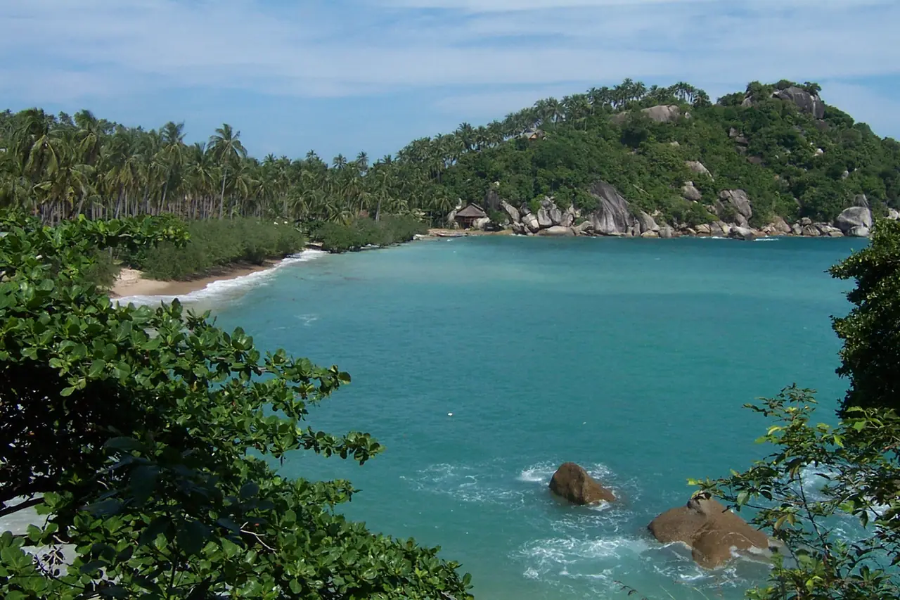 อ่าวหาดเตียนทางใต้ของเกาะพะงัน เห็นน้ำสีฟ้าเขียว ก้อนหินใหญ่ริมชายฝั่ง และป่ามะพร้าวเต็มแนวหาด ภาพนี้เป็นภาพอ่าวที่ Commons ระบุว่าเป็นหาดเตียน ไม่ใช่ภาพจากรีสอร์ตใดโดยเฉพาะ ภาพจาก Wikimedia Commons ผู้ถ่าย Micha Schmidt สัญญา CC BY-SA 2.5