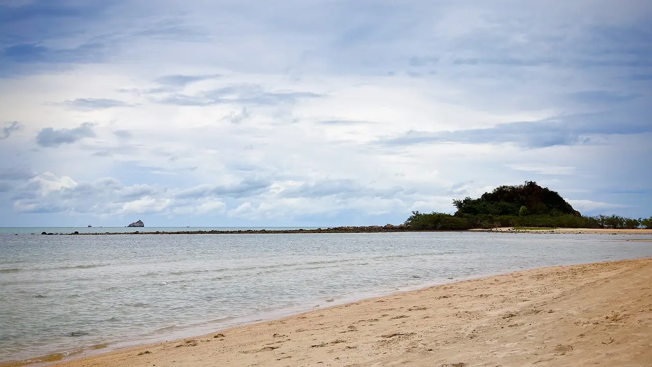 หาดเชิงมนช่วงน้ำนิ่ง ทรายยาวไปถึงเนินหญ้าและโขดหินกลางน้ำ ฟ้าครึ้ม ภาพที่ Commons ติดป้ายหาดเชิงมน ไม่ทราบวันที่ถ่าย ภาพจาก Wikimedia Commons ผู้ถ่าย Damian Moore สัญญา CC BY-SA 2.0