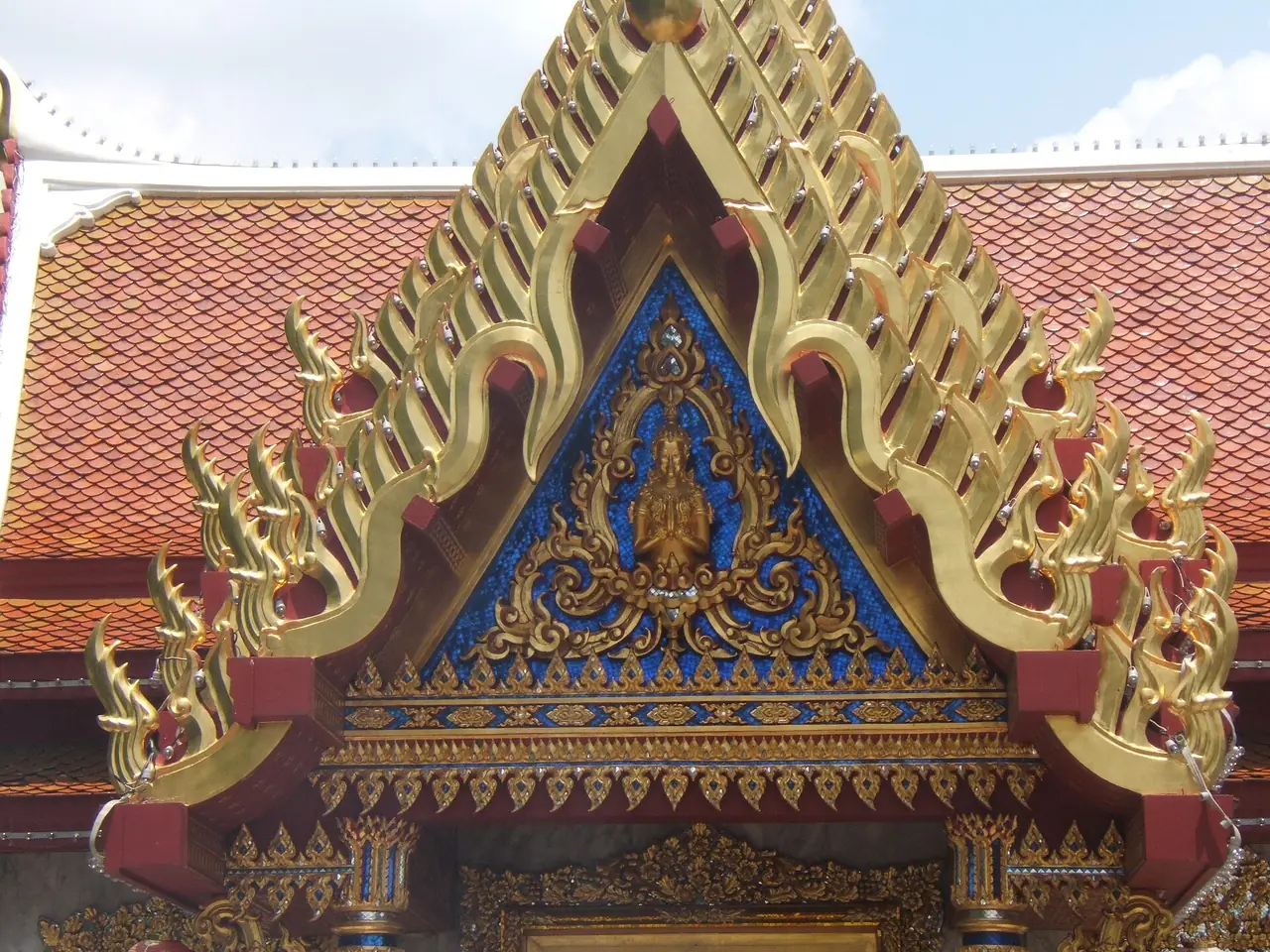 ลายหน้าบันสีทองบนพื้นสีน้ำเงินของศาลสมเด็จพระเจ้าตากสินมหาราช เมืองตาก ภาพจาก Wikimedia Commons ผู้ถ่าย Media lib สัญญา CC BY-SA 4.0 ชื่อไฟล์ระบุศาลที่เมืองตาก ไม่ใช่วัดพระบรมธาตุ